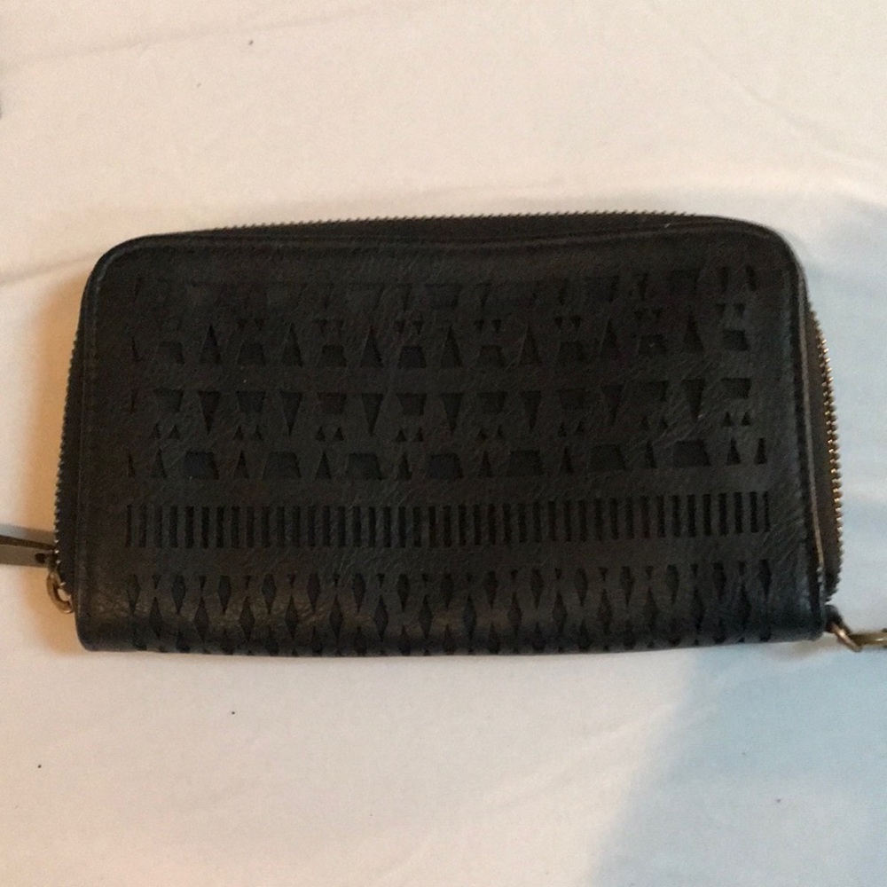 Black Laser cut wristlet secures with zipper card slots may hold mobile phone